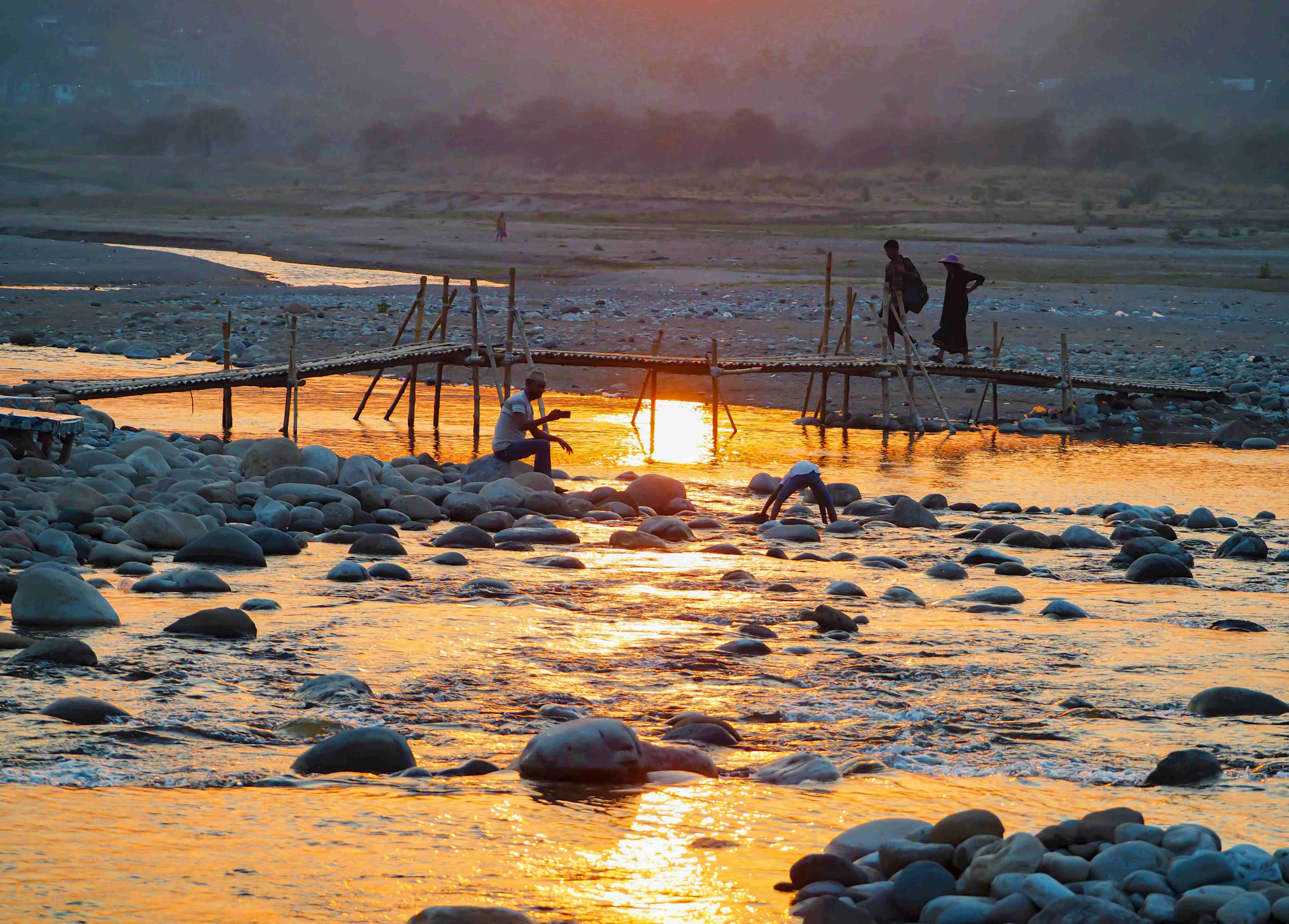 Golden sunset over Jaflong River with local people collecting stones